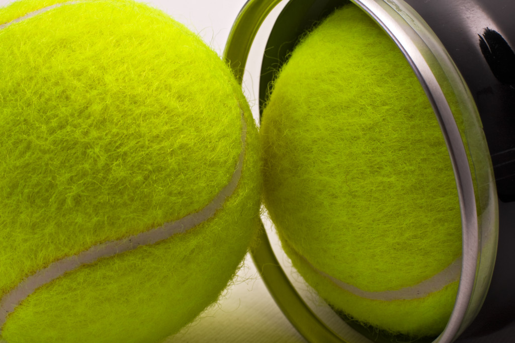 Yellow tennis balls out of black container